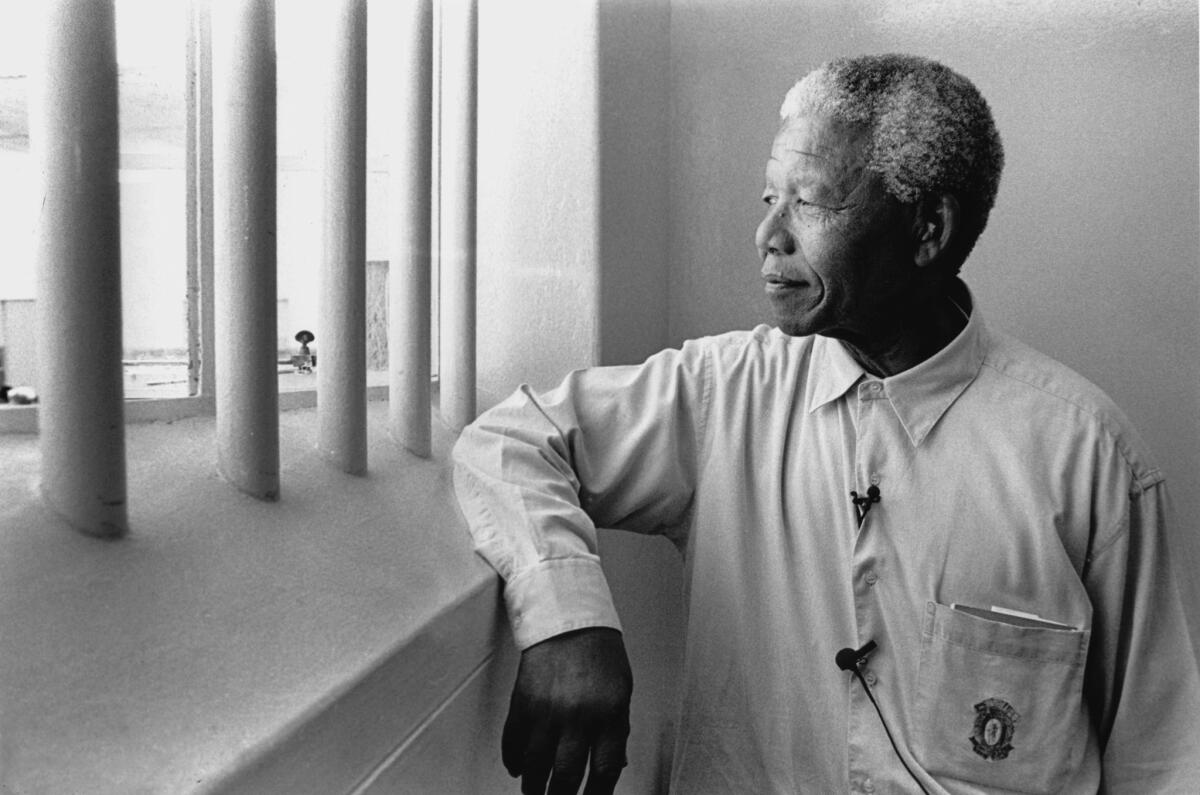 In 1994, Nelson Mandela, South Africa's first democratically elected black president, revisits his cell on Robben Island, where he spent eighteen of his twenty-seven years in prison. Photo by Jurgen Schadeberg/Getty Images.